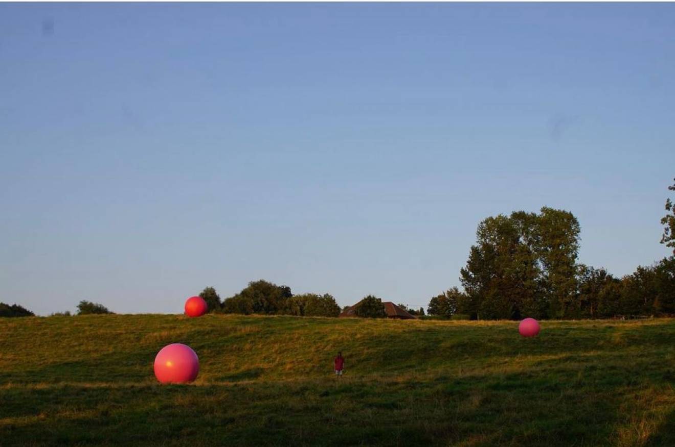 Miniature airtight inflatable balls airtight inflatable pink spheres in the Zwalm fields commissioned by artists Nora De Decker and Bjorn Pauwels X-Treme Creations