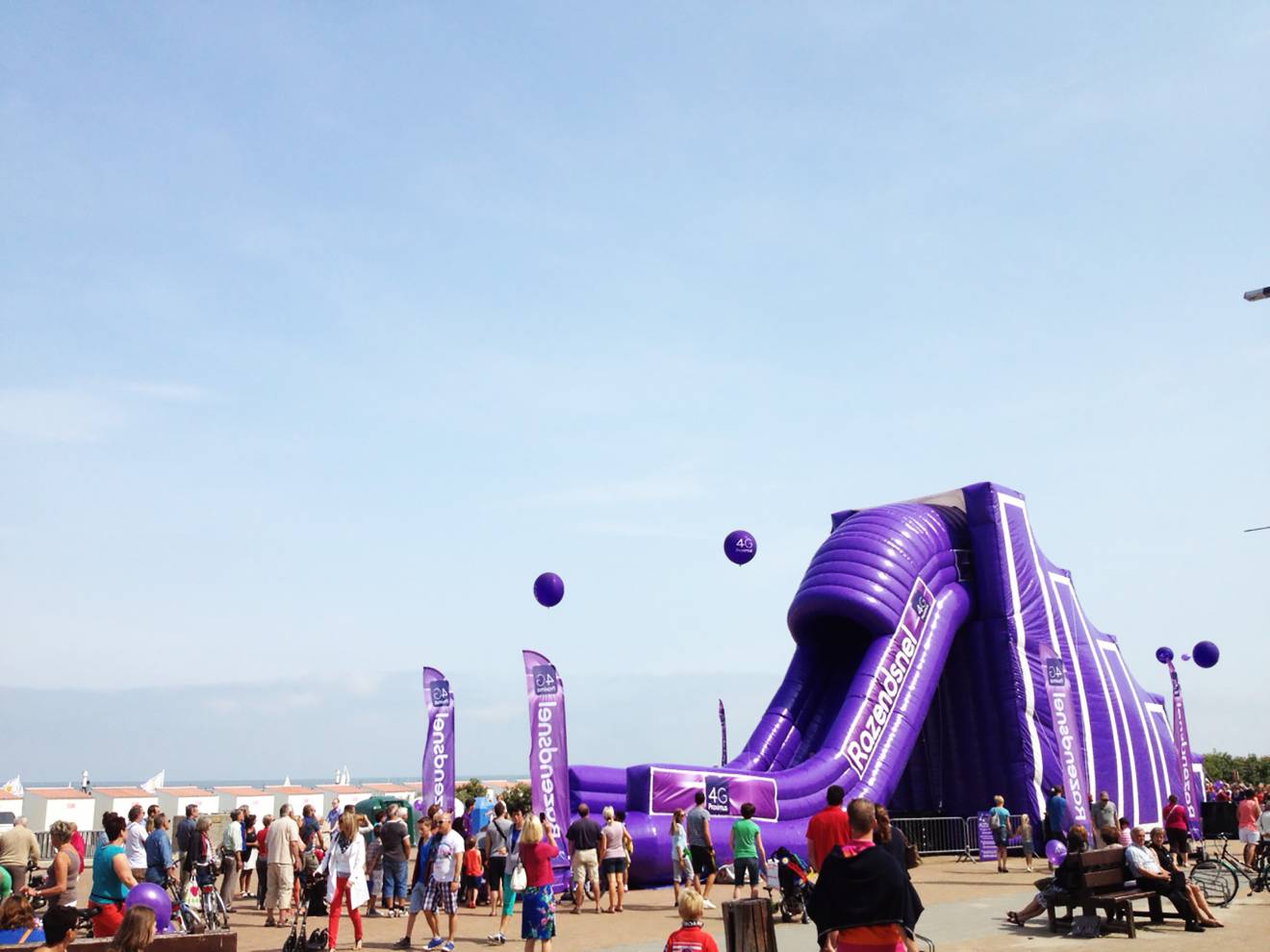 Giant inflatable games Opblaasbare  op maat gemaakte 10 m hoge glijbaan met klimtrap volledig in Proximus kleuren op het strand van Oostende gemaakt voor bureau Demonstr8 X-Treme Creations
