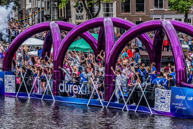 Corporate Branding Aufblasbare Arkaden aus violettem Spiegelstoff auf einem Boot während der Amsterdamer Grachtenparade für ein berühmtes Verhütungsmittel X-Treme Creations