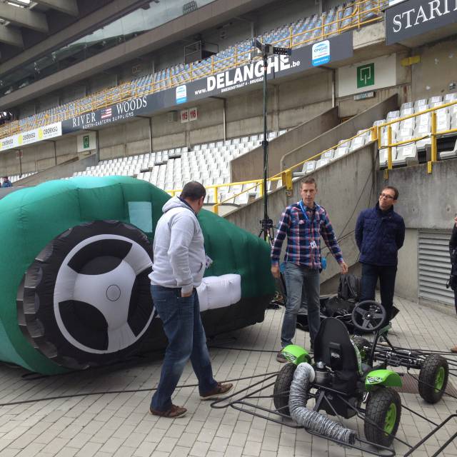X-Treme Creations Inflatable lawnmower Bosch with set of rechargeable batteries next to the field in an empty F.C. Bruges stadium with team X-Treme and a kart