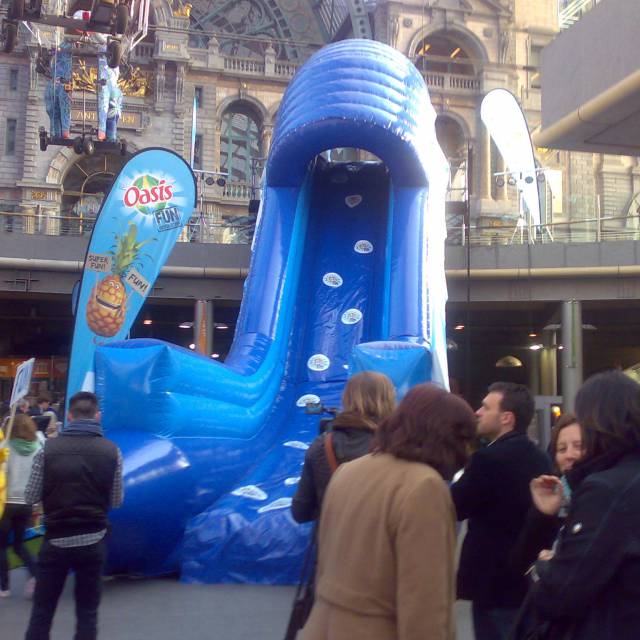 Giant inflatable games inflatable slide branded Oasis as interactive animation organised by FFWD agency in the Antwerp Central Trainstation X-Treme Creations
