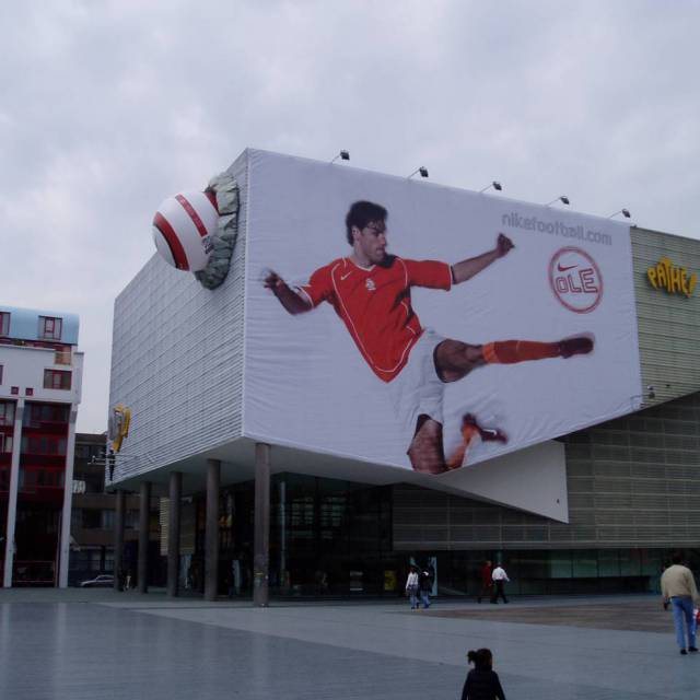 Combineer print en opblaasbaar materiaal permanente opblaasbare Nike voetbal in combinatie met full color dynamisch geprinte banner tegen de façade van Pathé Rotterdam X-Treme Creations
