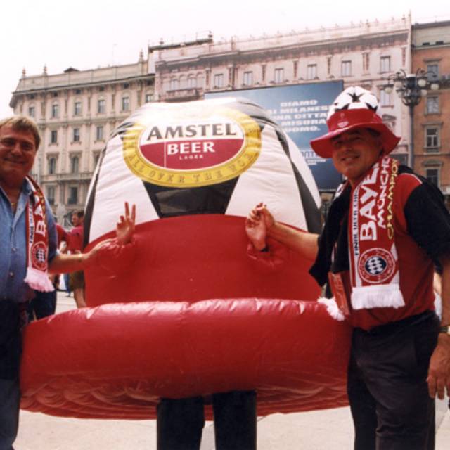 Giant inflatable costumes and walkers inflatable hat walker Amstel during Champions' League in the streets of the city of Milano X-Treme Creations