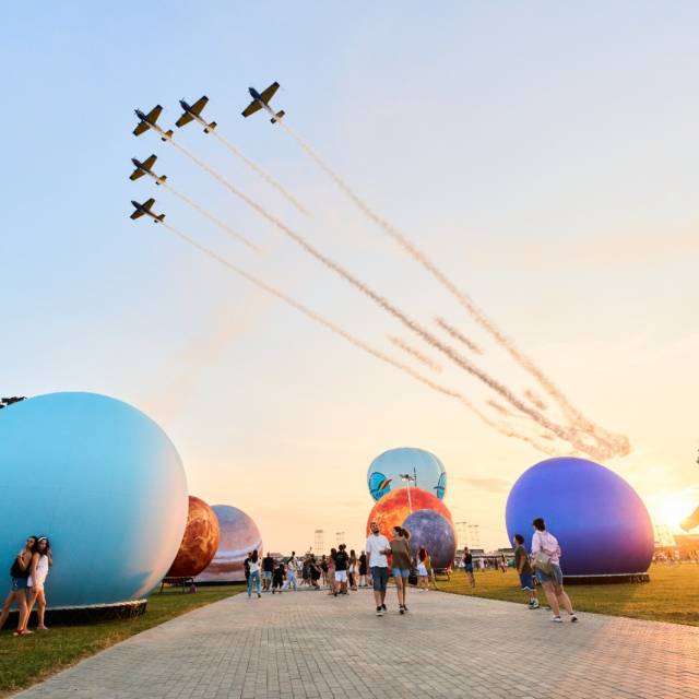 Sphères gonflables géantes Équipe nationale de cascadeurs survolant la route, encadrée par des planètes gonflables de part et d'autre, lors du festival Nibiru en Roumanie X-Treme Creations