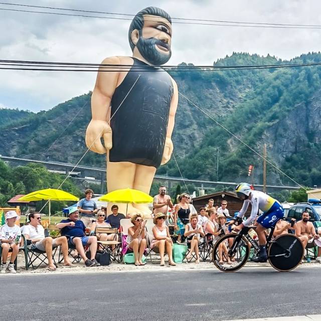 X-Treme Creations race cyclist passing in front of an inflatable character Médar during Tour de  France organised by the company ASO 