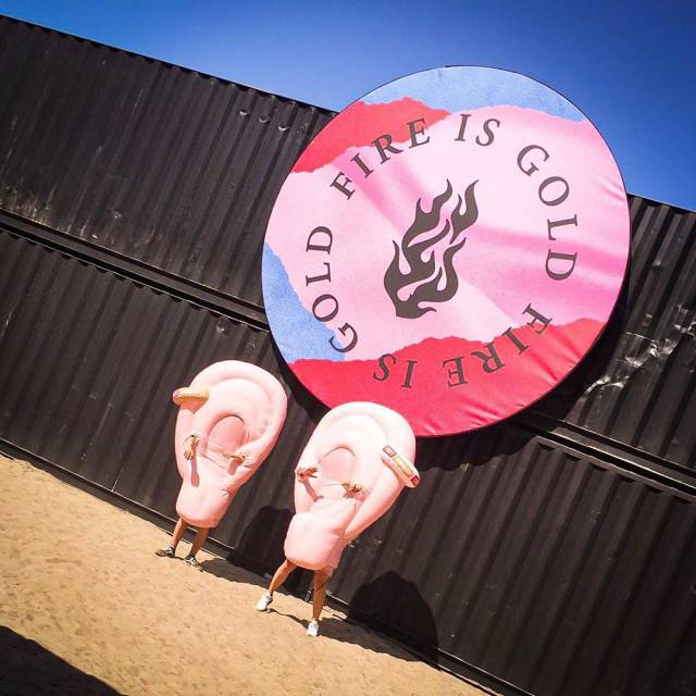 X-Treme Creations inflatable right and left ear walkers posing under the Fire is Gold festival logo
