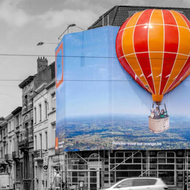 X-Treme Creations combination of inflatable balloon shape Orange with a large 2D frontlit banner against the façade of a building commissioned by the agency Pop-Media
