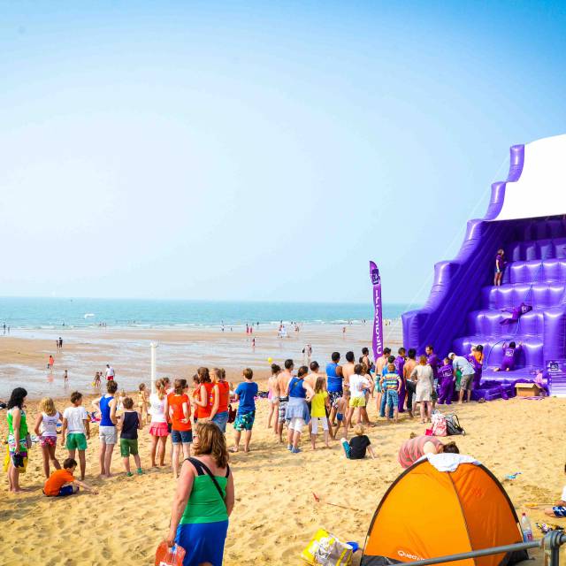 X-Treme Creations Purple inflatable 10 meter high slide queue on the beach in front of the climbing stairs 