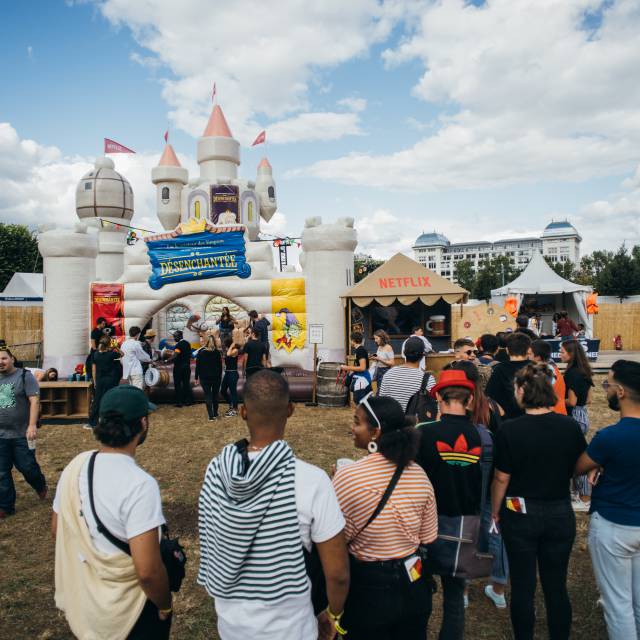 X-Treme Creations inflatable bouncy castle Netflix with a massive queue of visitors waiting to have a jump  that looks like a real castle with towers