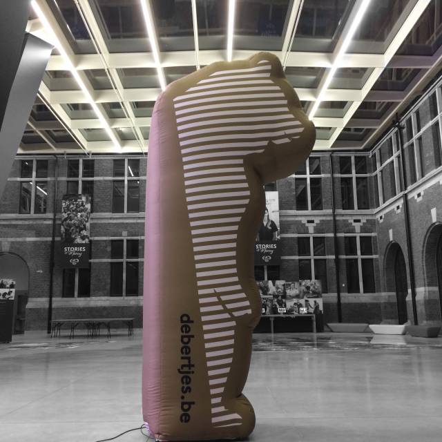 Mascottes et personnages gonflables géants prix géant De Bertjes sous la forme d'un ours 2D gonflable avec finition lisse par sublimation thermique et ventilateur permanent à l'intérieur de la belle Port House de Zaha Hadid Architects à Anvers X-Treme Creations