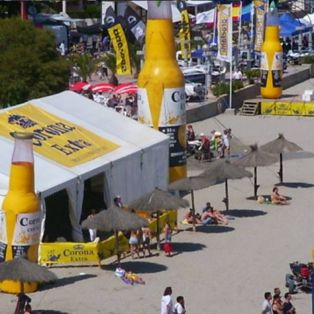 Large sized print banners Mesh banner 40 m2 Corona Extra for Jet Ski Championships on the beach in Murcia with an inflatable corona bottle  standing next to the tent X-Treme Creations