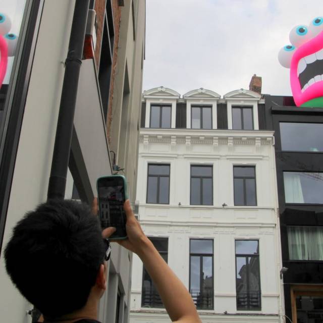 Big inflatable animals yellow monster with open mouth in center city during Antwerp on Air organised by Phil Blondé X-Treme Creations