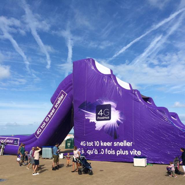 X-Treme Creations inflatable purple slide for animation on the beach with the slogan 4G to 10 times faster and the Proximus logo.