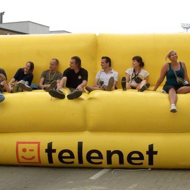 Giant inflatable meubels Opblaasbare Telenet-bank van 10 m breed met permanente externe ventilator die plaats biedt aan het team van E-Demonstations X-Treme Creations