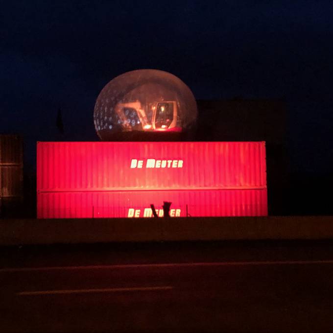 Groot opblaasbaar promotiemateriaal | X-Treme Creations Transparante bubble van 6 meter op een 5 meter hoog platform van 40 en 20 voet rode containers met een graafmachine erin Events  & Beurzen  & Festivals  & Merkactivatie  &  De Meuter Wave X-Treme Creations