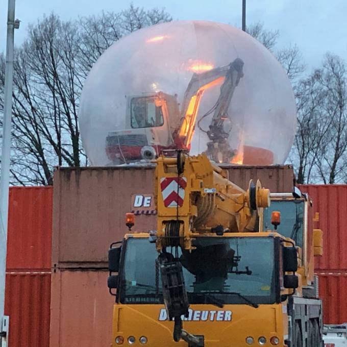 Large inflatable promotional material | X-Treme Creations Transparent bubble of 6m located on a 5m high platform of 40 and 20 foot red containers with an excavator in it Events  & Fairs  & Festivals  & Brand activation  &  De Meuter Wave X-Treme Creations